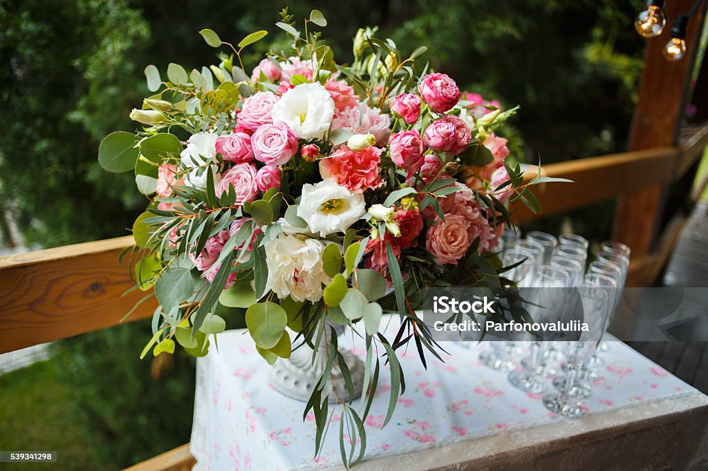 beautiful floral arrangement of pink and white peonies, roses bright bouquet of peony on the wedding table with glasses on a green background Rose - Flower Stock Photo