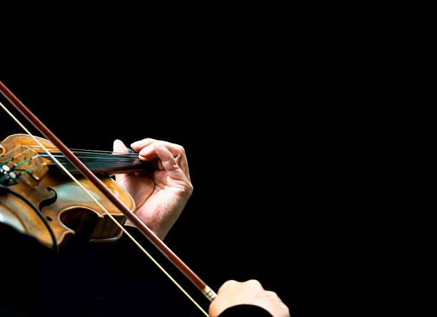 istock Closeup violinist hands playing violin against black background, copy space 539344457