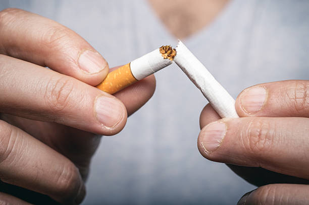 istock Quit smoking - male hand crushing cigarette 539345300