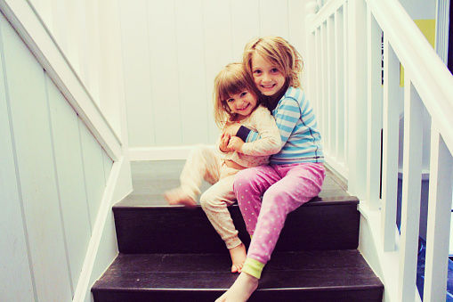 Two sisters affectionate on the stairs