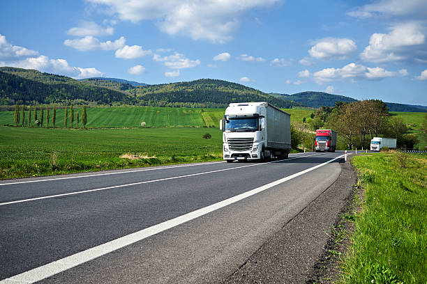 istock Rural landscape with asphalt road and oncoming three trucks. 539349872