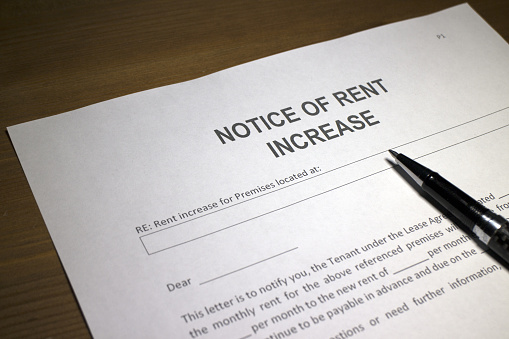 Someone filling out Notice of Rent Increase.