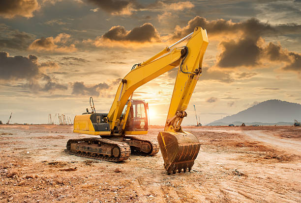 excavator loader machine during earthmoving works outdoors excavator loader machine during earthmoving works outdoors in sunset backhoe photos stock pictures, royalty-free photos & images