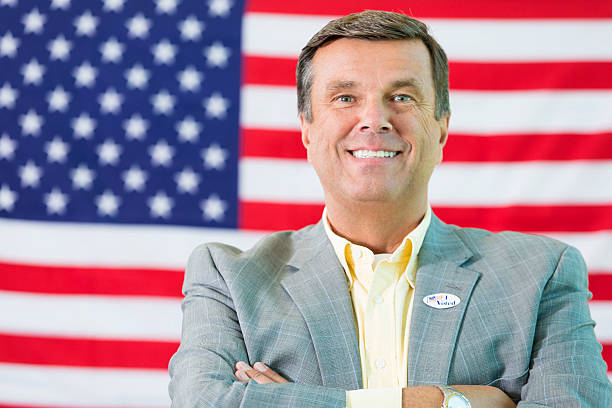istock Happy man standing in front of American flag 539356058