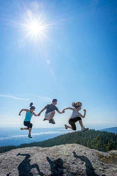 istock Family Jumping in Row on Mountain Top, Holding Hands 539357837