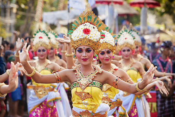 Balinese women dancing traditional temple dance Denpasar, Bali Island, Indonesia - June 13, 2015: Beautiful women group dressed in colorful sarongs - Balinese style female dancer costume, dancing traditional temple dance Legong at Bali Art and Culture Festival gala parade balinese culture stock pictures, royalty-free photos & images