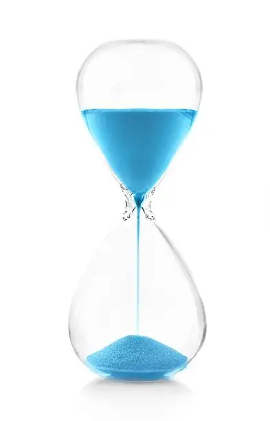 time concept, blue sand running through the bulbs of an hourglass measuring the passing time. isolated on white background, close up