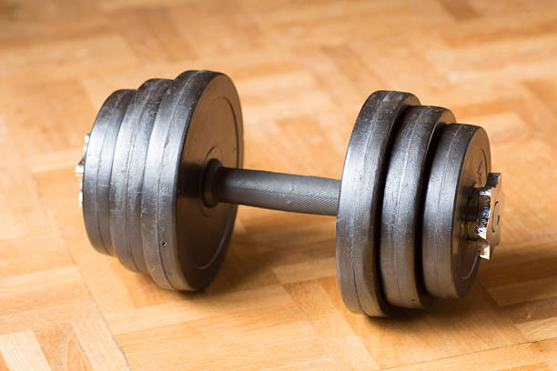 istock Black rubber dumbbell on the wooden floor 539358586