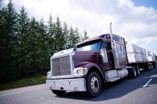 istock Big rig semi truck with lumber cargo on flat bad 539359478