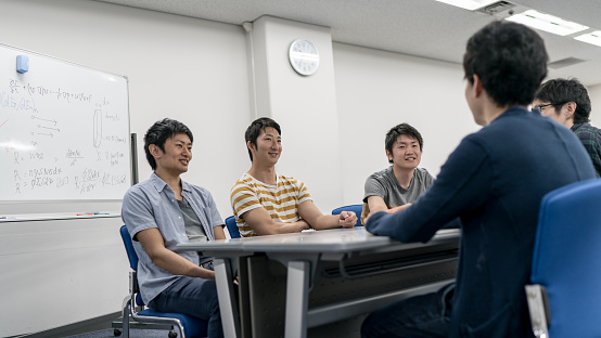 There are five university students are discussing at a  meeting room.