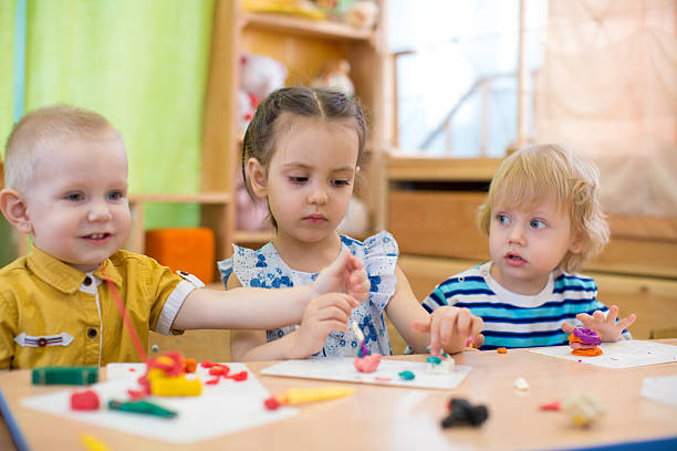istock kids doing arts and crafts in day care kindergarten 539361362