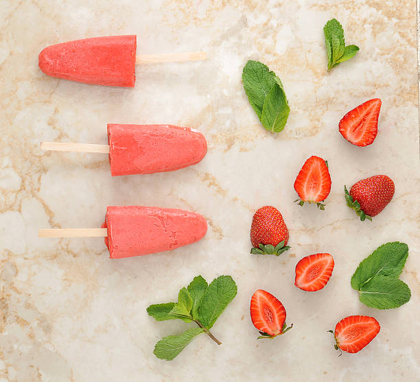 istock Strawberry yogurt ice cream popsicles with mint over marble tray 539361540