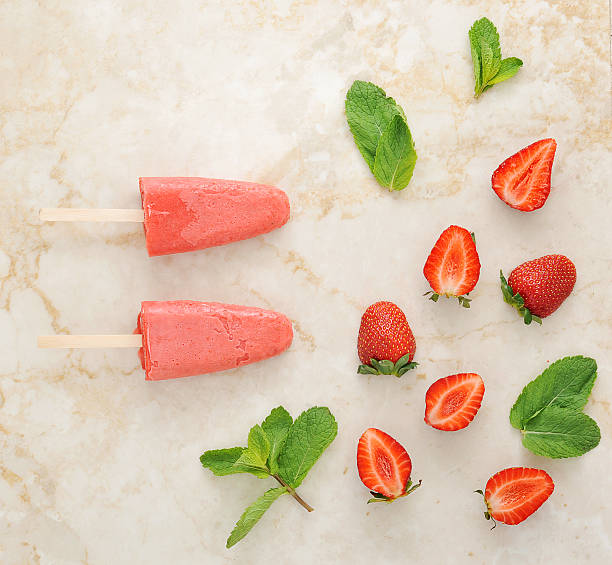 istock Strawberry yogurt ice cream popsicles with mint over marble tray 539361570