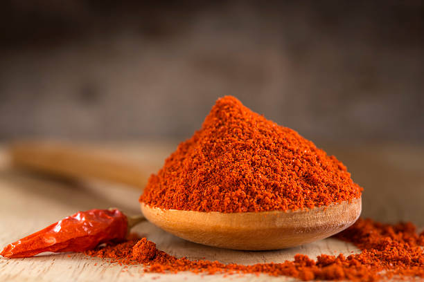 Spoon filled with red hot paprika powder stock photo
