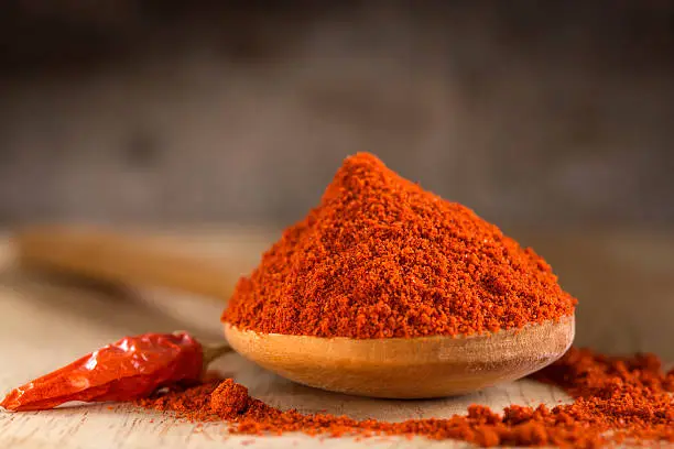 Photo of Spoon filled with red hot paprika powder