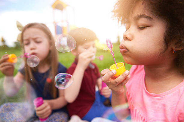 soplar las burbujas con mis amigos - bubble child bubble wand blowing fotografías e imágenes de stock