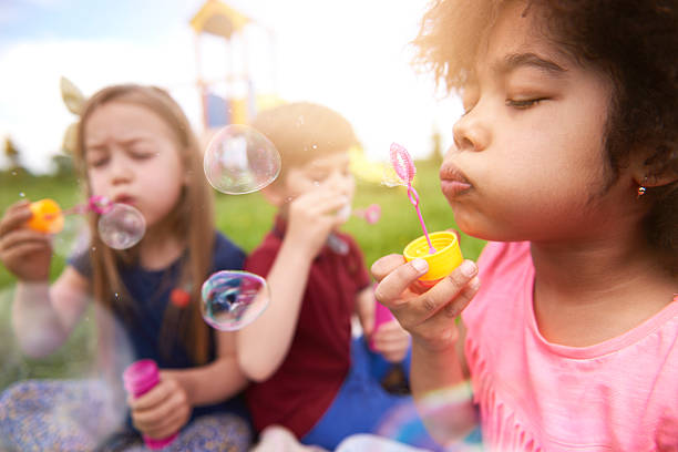 sopros as bolhas com os meus amigos - bubble child bubble wand blowing imagens e fotografias de stock