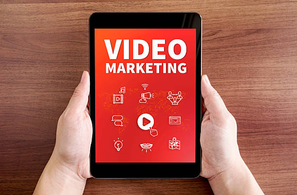 istock hand holding tablet with Video marketing and icon on screen 539366074