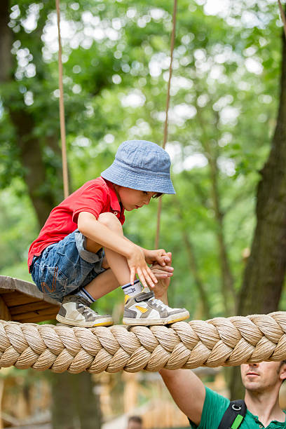 istock Cute child, boy, climbing in a rope playground structure 539369868