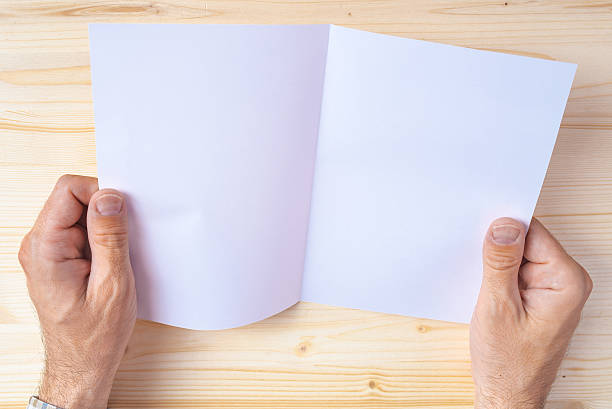 istock Man holding blank brochure as mock up copy space 539370106