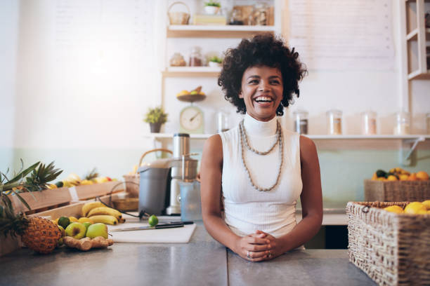 Happy juice bar owner Portrait of young african woman standing behind juice bar counter looking at camera and smiling. Happy juice bar owner. juice bar stock pictures, royalty-free photos & images