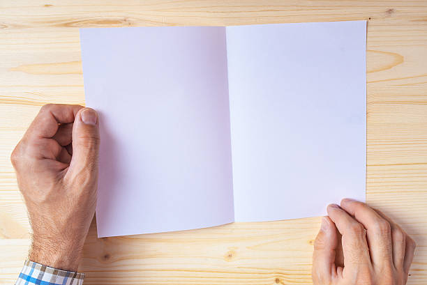 istock Man holding blank brochure as mock up copy space 539370206