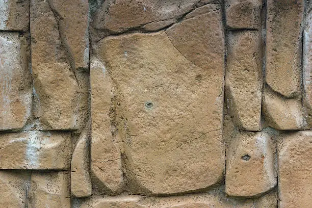 Light brown stones of varying sizes built into a wall, can be used as background