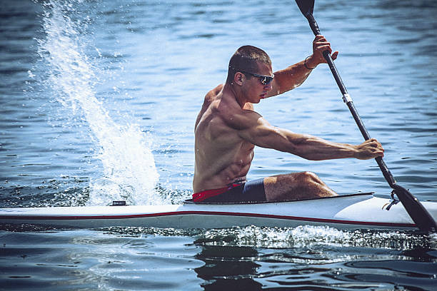 musculaire jeune homme en kayak de vitesse entraînement sur encore de l " eau. - skiff photos et images de collection