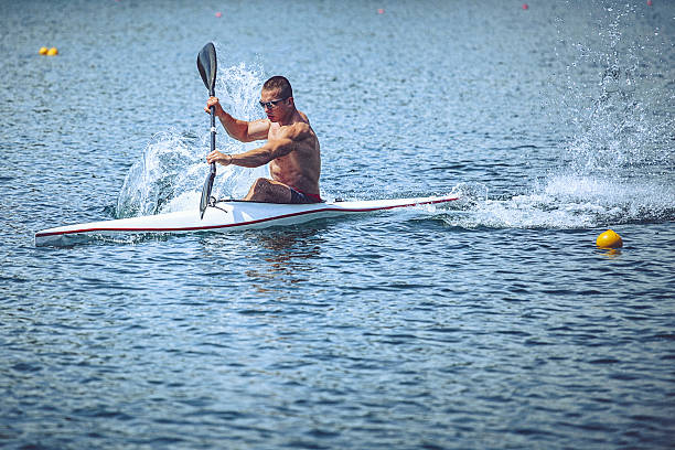 musculaire jeune homme en kayak de vitesse entraînement sur encore de l " eau. - skiff photos et images de collection