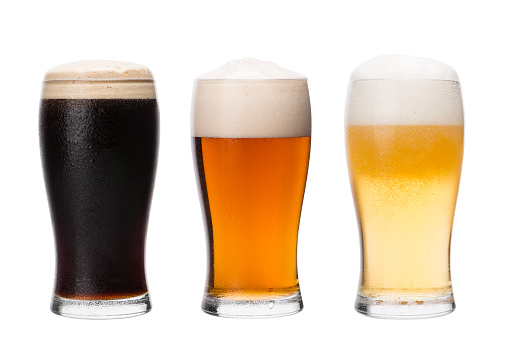 Three wet pint glasses filled with different type home made beer: yellow, red and black. Making home brew process concept. Isolated on white background image. 