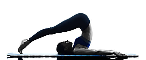 woman pilates exercises fitness isolated one caucasian woman exercising pilates exercises fitness in silhouette isolated on white backgound shoulder stand stock pictures, royalty-free photos & images