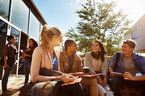 Work with the people that motivate and inspire you Shot of a group of students studying outside on campus adult student stock pictures, royalty-free photos & images