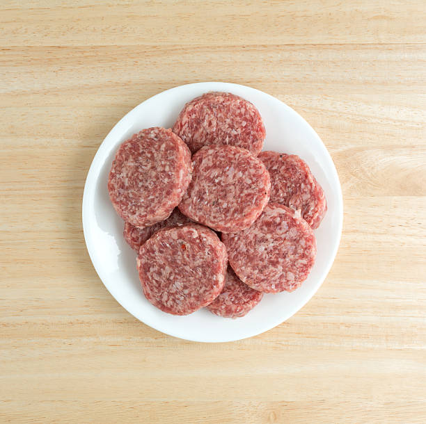 istock Sausage patties on a white plate atop a table 539446938