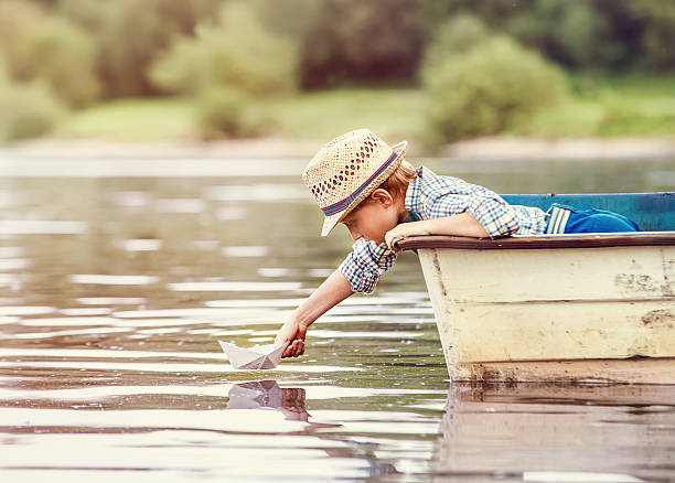 istock Little boy launch paper ship from old boat 539447820