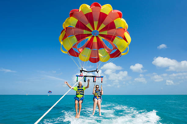 Para sailing near coast Key West, Florida, USA - May 02, 2016: An elderly couple is para sailing with a rope pulled by a boat near Key West in Florida parasailing stock pictures, royalty-free photos & images