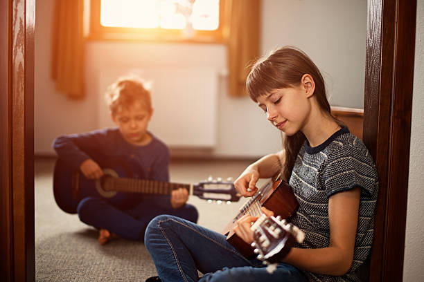 istock Sister and brother playing guitars together 539463894