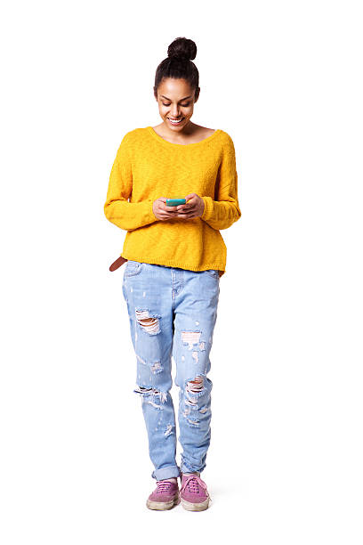 señora joven feliz lectura mensaje de texto en su teléfono celular - isolated on white full length lifestyles yellow fotografías e imágenes de stock