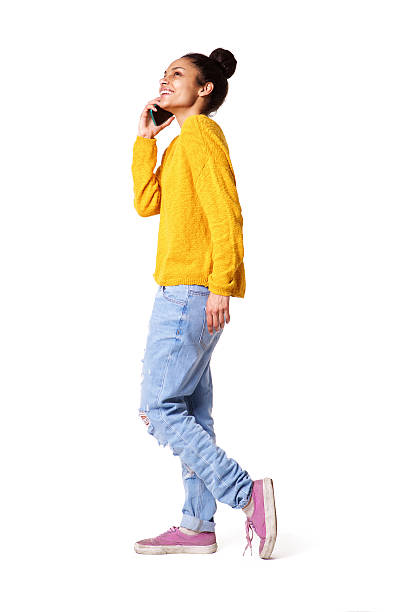 elegante mujer joven hablando por teléfono móvil - isolated on white full length lifestyles yellow fotografías e imágenes de stock
