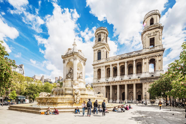 Paris, France - May 3, 2016: The famous cathedral Saint Sulpice in Paris, France. It was erected between the 12th and 18th century. It is one of the biggest cathedrals in Paris with huge paintings inside. Tourists are strolling in front of the cathedral and the fountain.