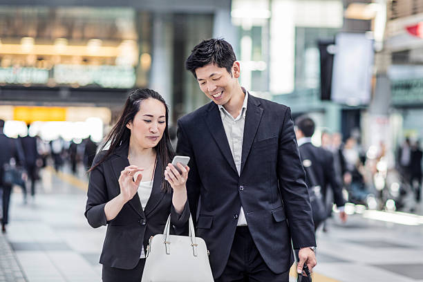 japonês pessoas de negócio como meio de transporte para a estação de trabalho - rush hour commuter on the phone tokyo prefecture - fotografias e filmes do acervo