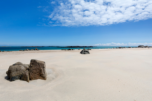 Rocks on a sandy beach on the channel island of Herm, UK, Europe, at low tide