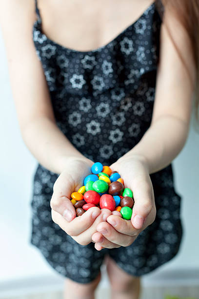 istock Little girl holding candy in the hands 539472018