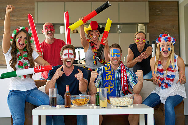 many happy international soccer fans watching tv