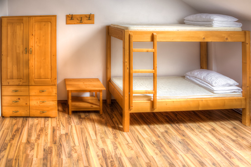 Clean hostel room with wooden bunk beds.