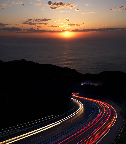istock Car lights with sunset and sea in the background. 539478890