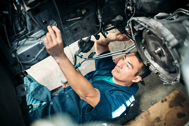 Car Mechanic Working Under Vehicle Overhead view of a car mechanic working under a vehicle, once the engine has been removed. car mechanic top view stock pictures, royalty-free photos & images