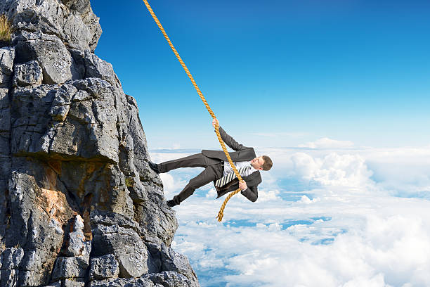 istock Businessman climbing on mountain with rope 539643302