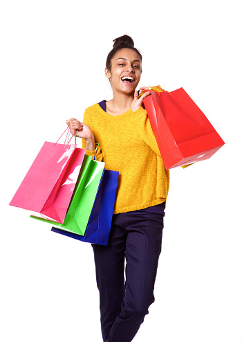 Portrait of attractive black woman smiling and holding shopping bags on white background