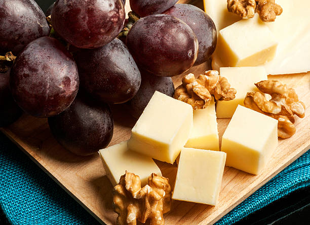 Macro of red grapes, cheeses and walnus.