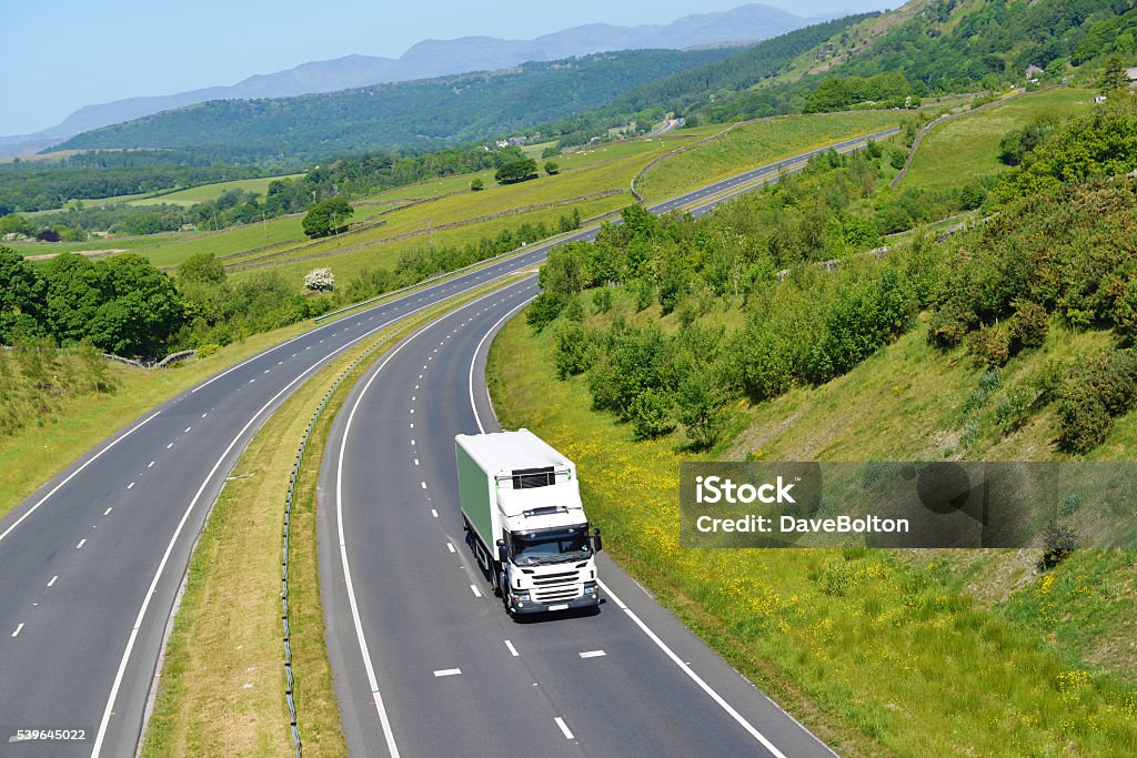 Refrigerated Rigid Goods Vehicle on Open Road Large refrigerated goods vehicle on open road heading south away from the English Lake District mountains on a perfect Spring day. Truck Stock Photo